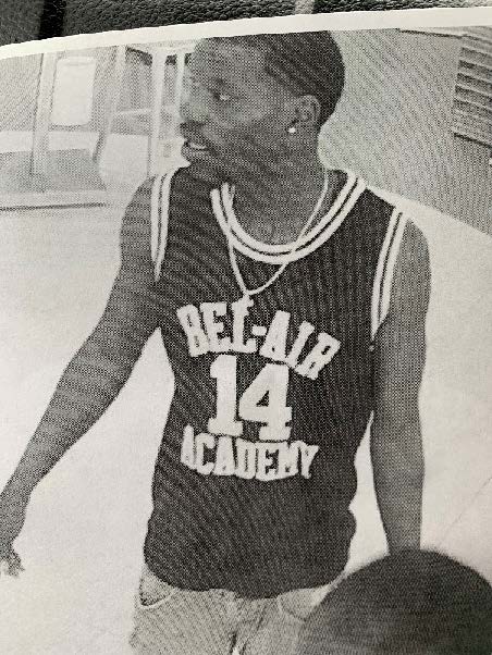 Gray surveillance photo of second suspect wearing a jersey with the words "Bel-Air Academy 14"